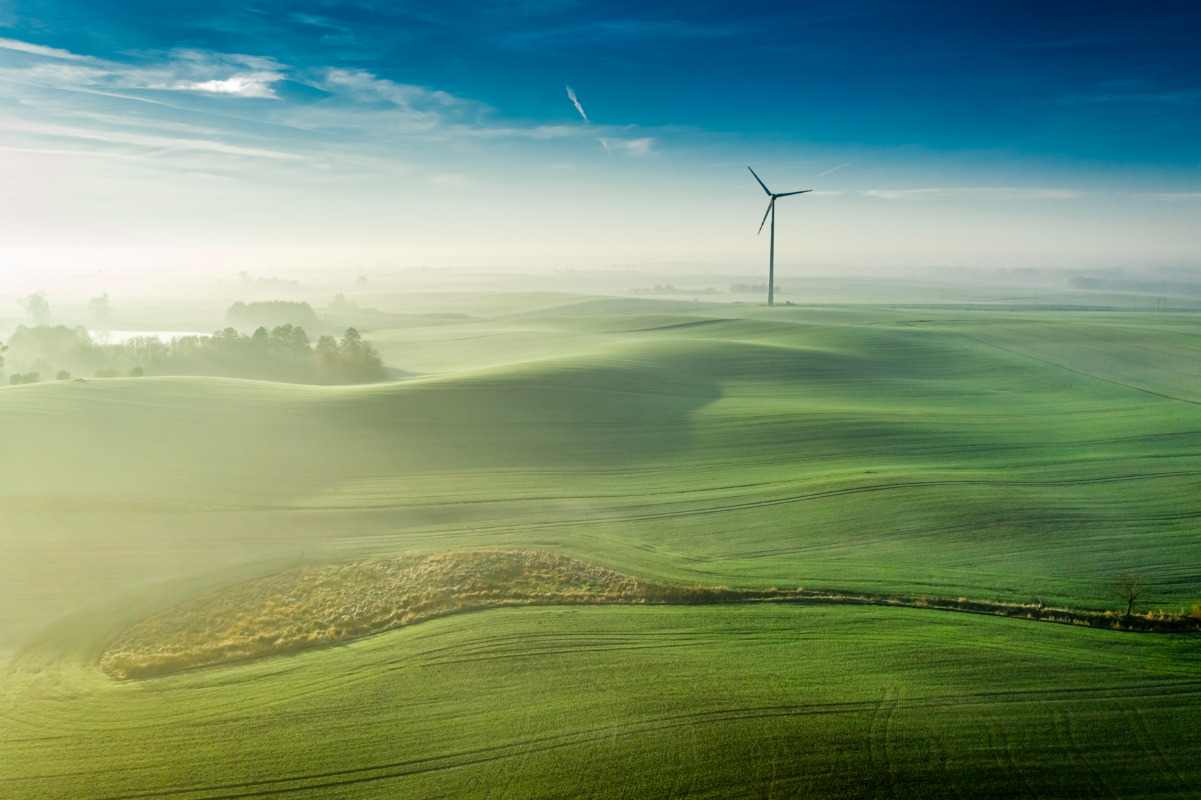 Stunning foggy sunrise over green hills, view from above